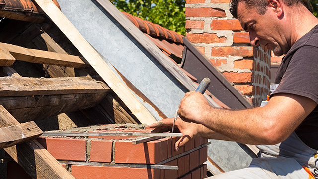Working detail on brick chimney on an old roof